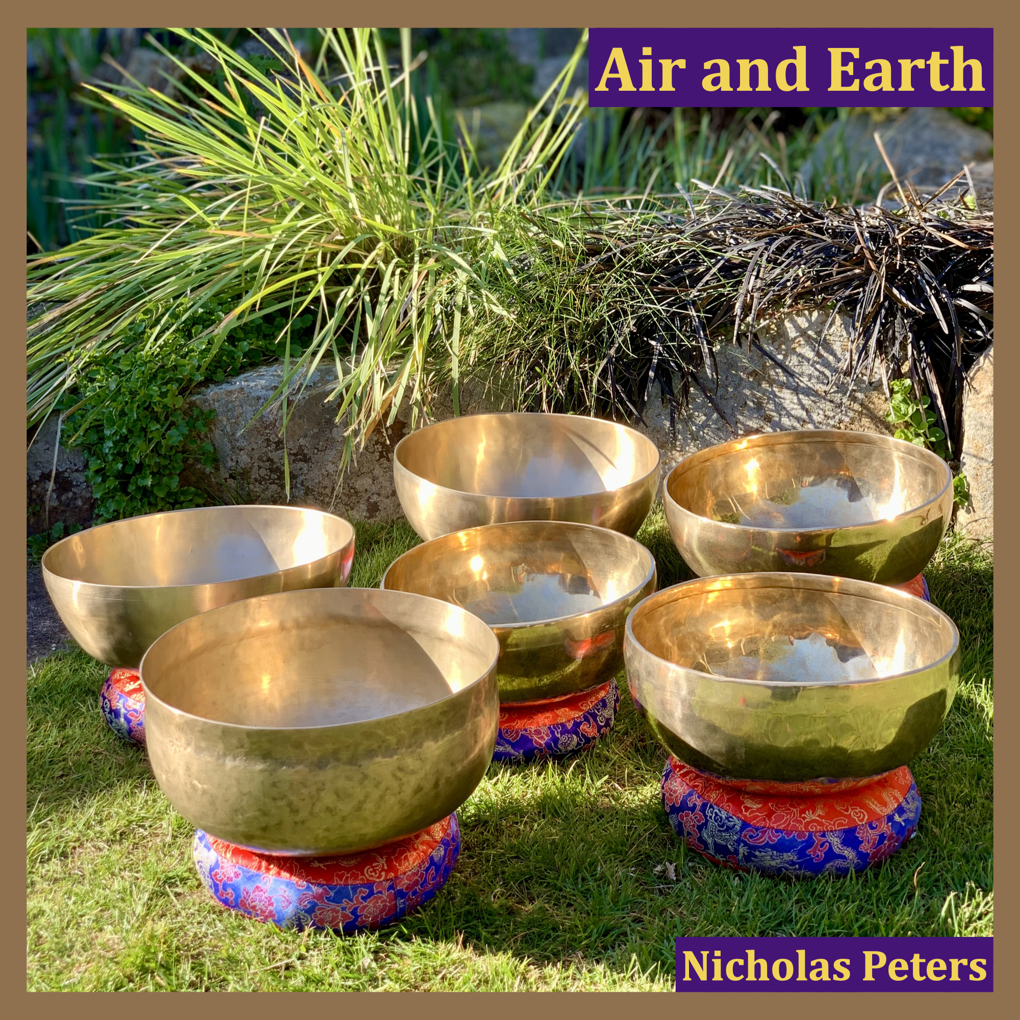 Single artwork with text that reads: “Air and Earth by Nicholas Peters". The photograph in the artwork shows five modern Himalayan singing bowls and an antique Ultabati bowl. The bowls are all resting on brocade cushion rings on grass with sunlight shining on them. Behind the bowls is a flower border with plants.