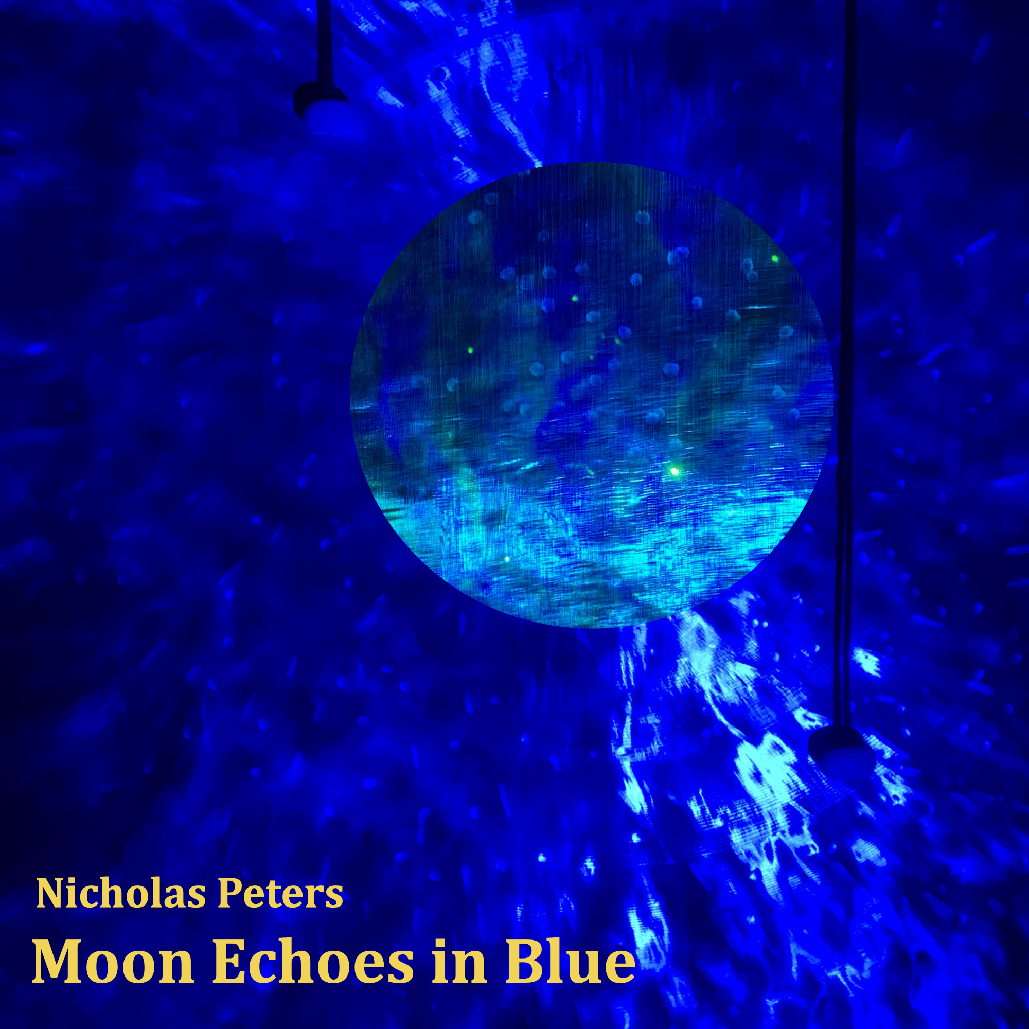 Single artwork with yellow coloured text that reads: “Nicholas Peters -“ Moon Echoes in Blue. The photograph in the artwork shows a close-up shot of the front of a 70cm Thomann wind gong with deep blue nebula light projections shining on it. There are two blue Echoes (gong gadgets by Epic Mallets) that can be seen hanging down from the top of the gong, the one on the right is longer than the one on the left. The centre of the gong looks lighter, almost like a moon.